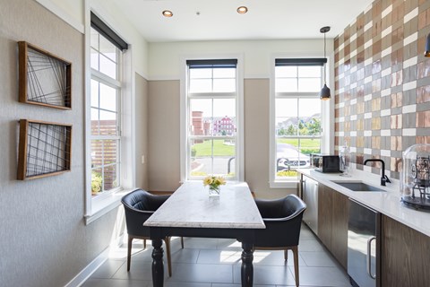 A kitchen with a table and chairs in front of a window.