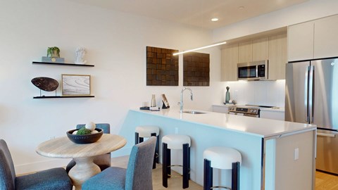 A modern kitchen with a dining table and chairs.