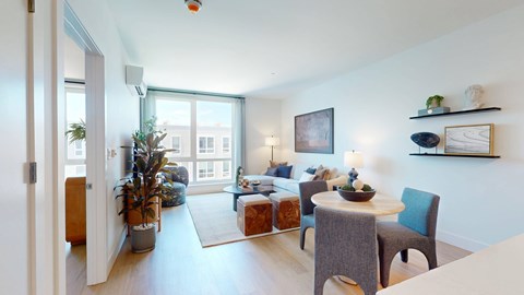A living room with a couch, chairs, and a dining table.