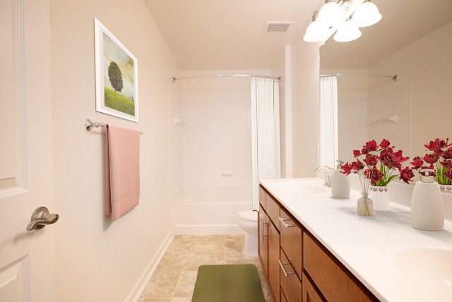 A bathroom with a white counter and a green stool.