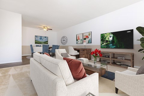 A living room with a white couch and a television on the wall.