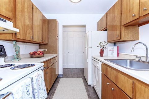A kitchen with wooden cabinets and white appliances.