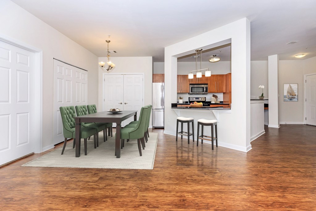 A kitchen with a dining table and chairs.