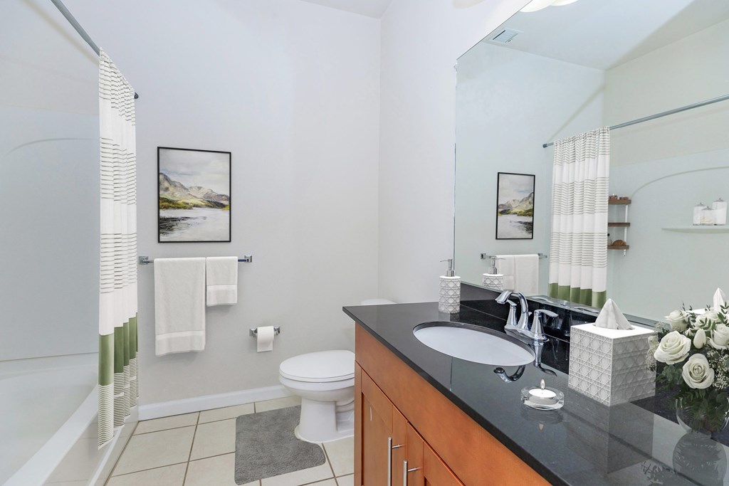 A bathroom with a white toilet, a sink, and a shower.