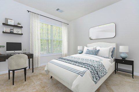 A bedroom with a bed, desk, and chair.
