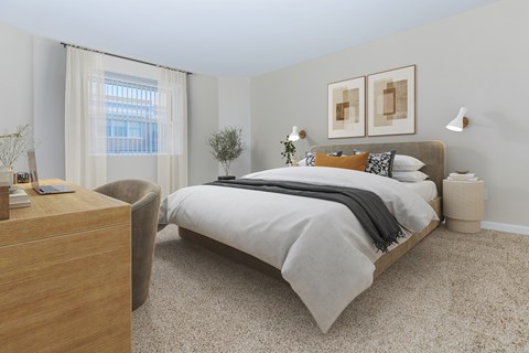 A bedroom with a large bed and a chair.