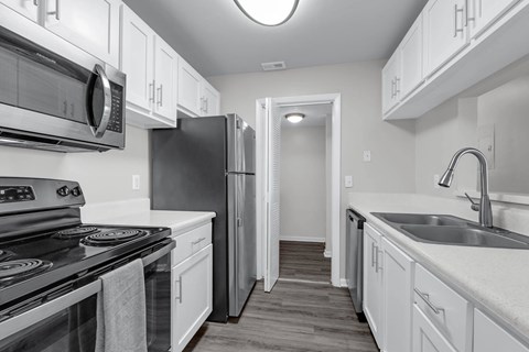 A black refrigerator in a white kitchen.