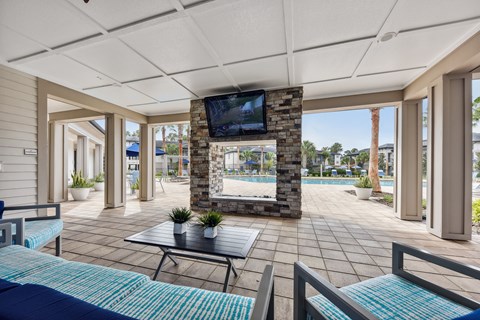A living room with a television and a pool in the background.