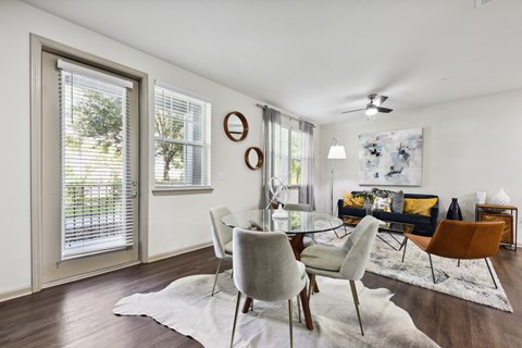 A modern dining room with a glass table and chairs.
