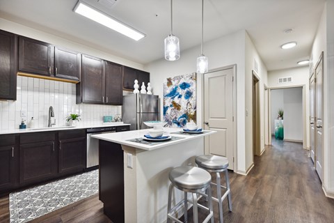 A kitchen with dark brown cabinets and a white island.