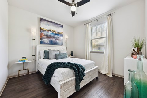 A bedroom with a large bed and a painting on the wall.