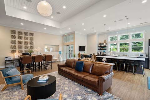 A living room with a brown leather couch and a black coffee table.