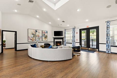 A living room with a white circular couch and a fireplace.