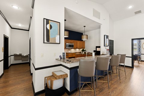 A modern kitchen with a bar area and a dining table.