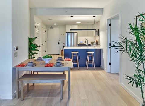 A modern kitchen with a dining table set for two.