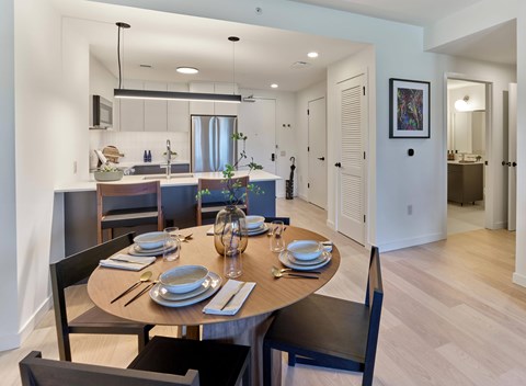 A dining room with a table set for a meal.