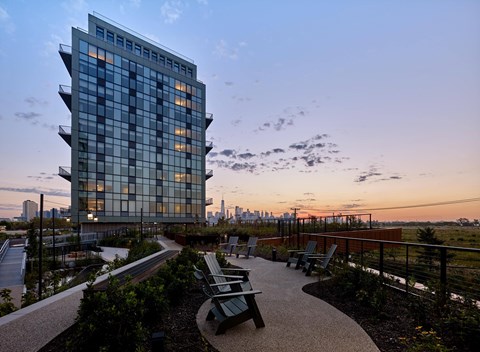A modern glass building with a walkway in front of it.