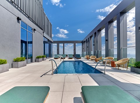 a swimming pool on the rooftop of a building with a blue sky
