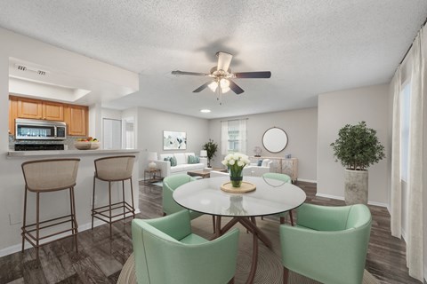 A dining room with a white table and green chairs.