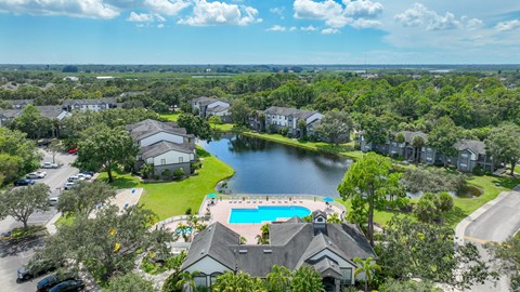 A bird's eye view of a resort with a swimming pool and a lake.