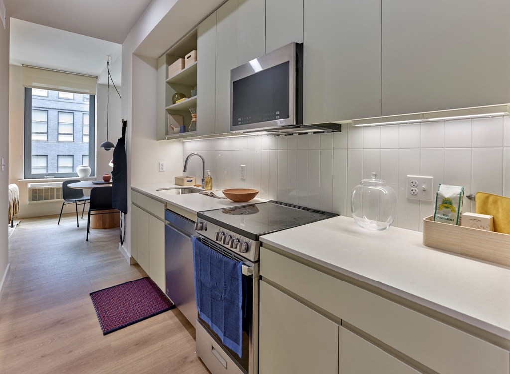a kitchen with a stove and a sink and a television