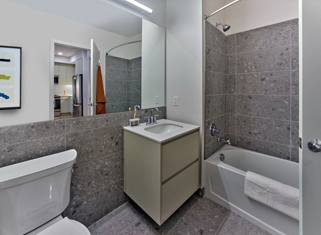 a bathroom with a sink toilet and tub and a mirror