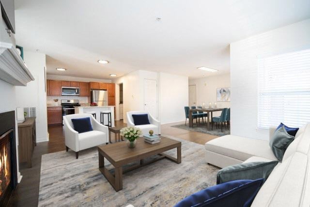 A living room with a fireplace and a dining area in the background.