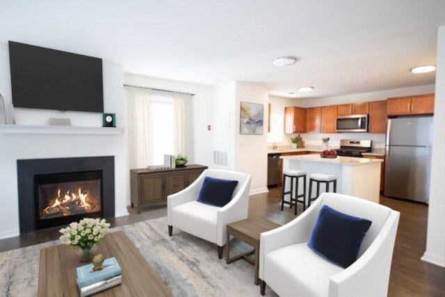 A living room with a fireplace and two chairs.