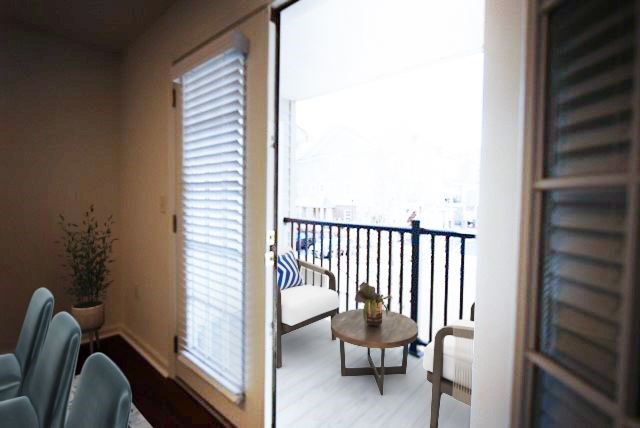 A balcony with a table and chairs is visible through a sliding glass door.