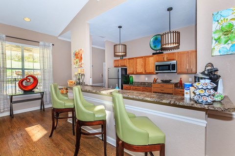 A kitchen with a counter and chairs.