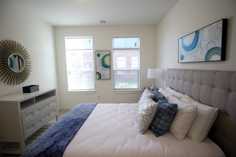 A bedroom with a large bed and a mirror on the wall.