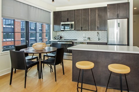 A kitchen with a table and chairs.