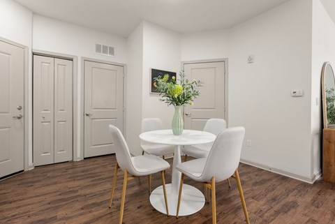 A dining room with a white table and chairs.