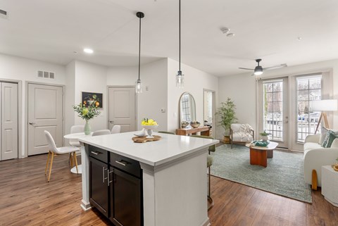 A modern kitchen with a white island and black appliances.