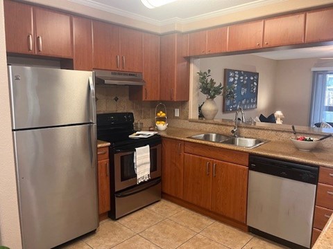 A kitchen with a stainless steel refrigerator and a black oven.
