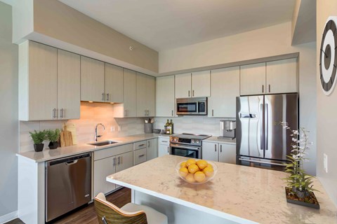 A kitchen with a bowl of oranges on the counter.