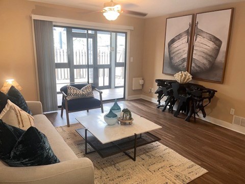 A living room with a couch, chairs, and a painting on the wall.