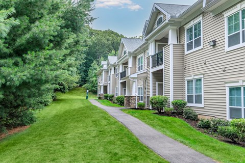 A row of houses with green lawns in front.