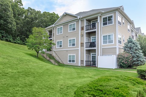 A large apartment building with a green lawn in front.