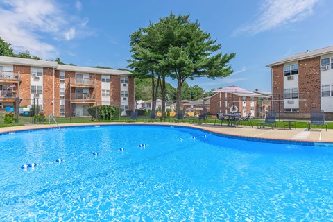 A swimming pool in front of apartment buildings.