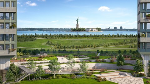 A green park with a statue of liberty in the background.