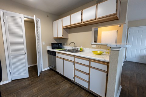 A kitchen with white cabinets and a wooden counter top.
