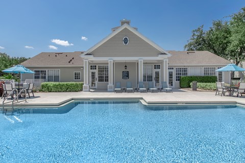 A house with a pool in front.