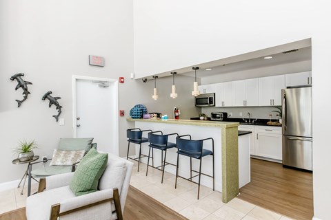 A kitchen with a white counter and a white chair.