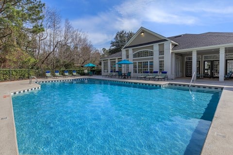 A large swimming pool in front of a house.