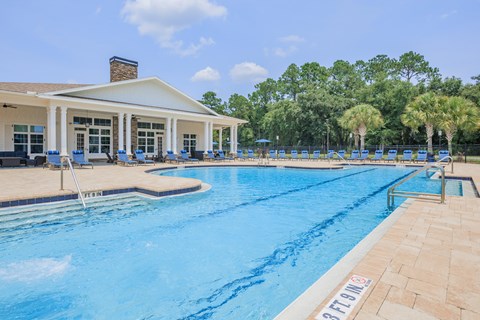 A large swimming pool with a building in the background.