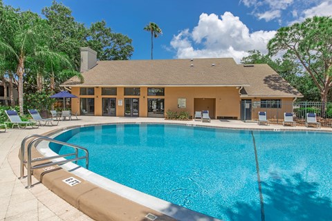 A swimming pool in front of a building with a brown roof.