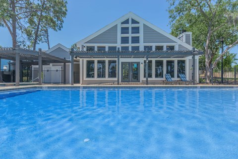 A house with a pool in front of it.