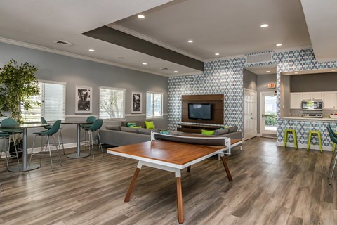 A modern living room with a wooden table and green chairs.