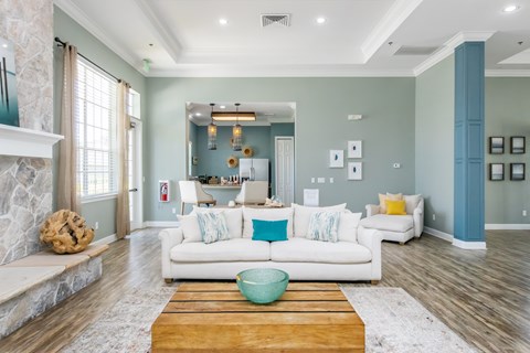 A living room with a white couch and a wooden coffee table.